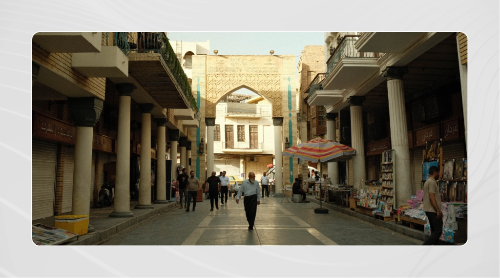 Photo of Mutanabbi Street in Baghdad city, with people walking down the street looking at books and cultural items.